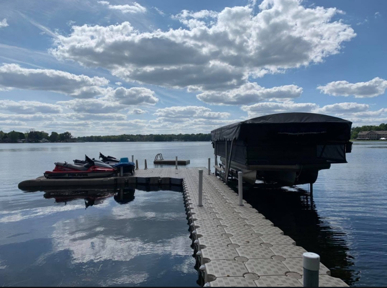 Michigan lakefront with personal watercraft on a floating dock beside a covered boat lift