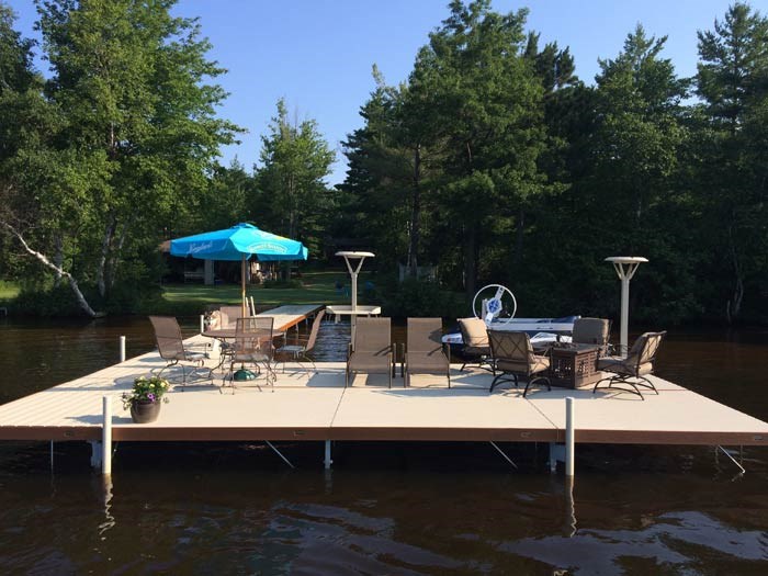 Existing lake dock furnished with seating, tables, umbrellas, and waterfront accessories