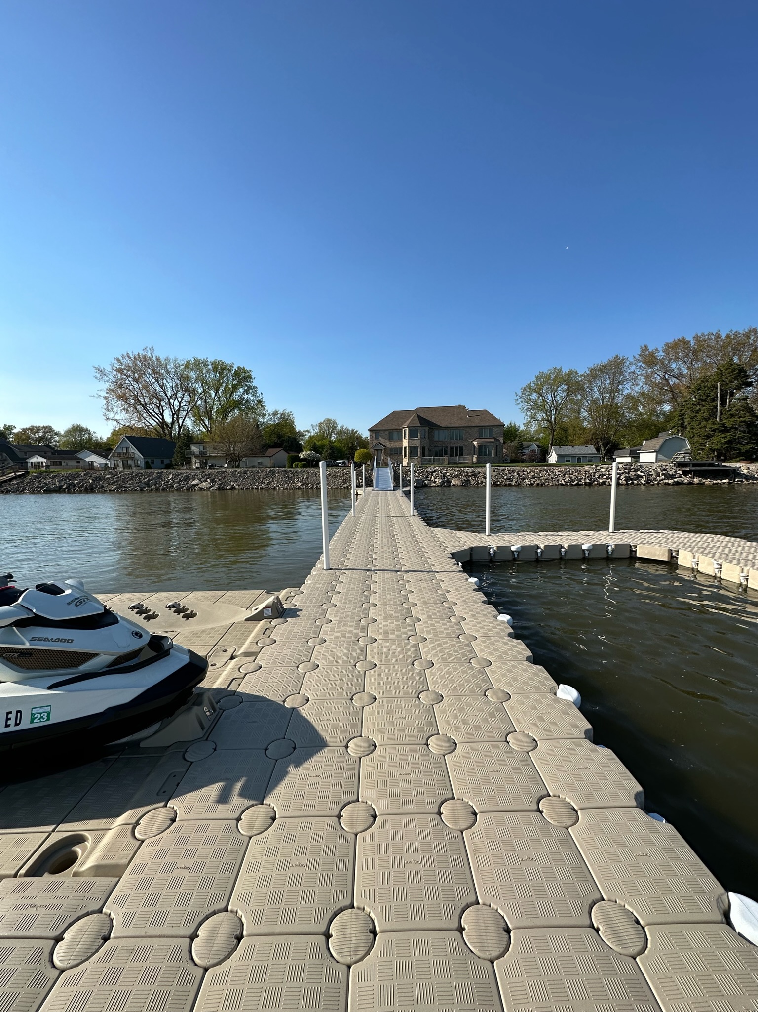 Long grey CanDock walkway extending through a marina with boat slips on both sides