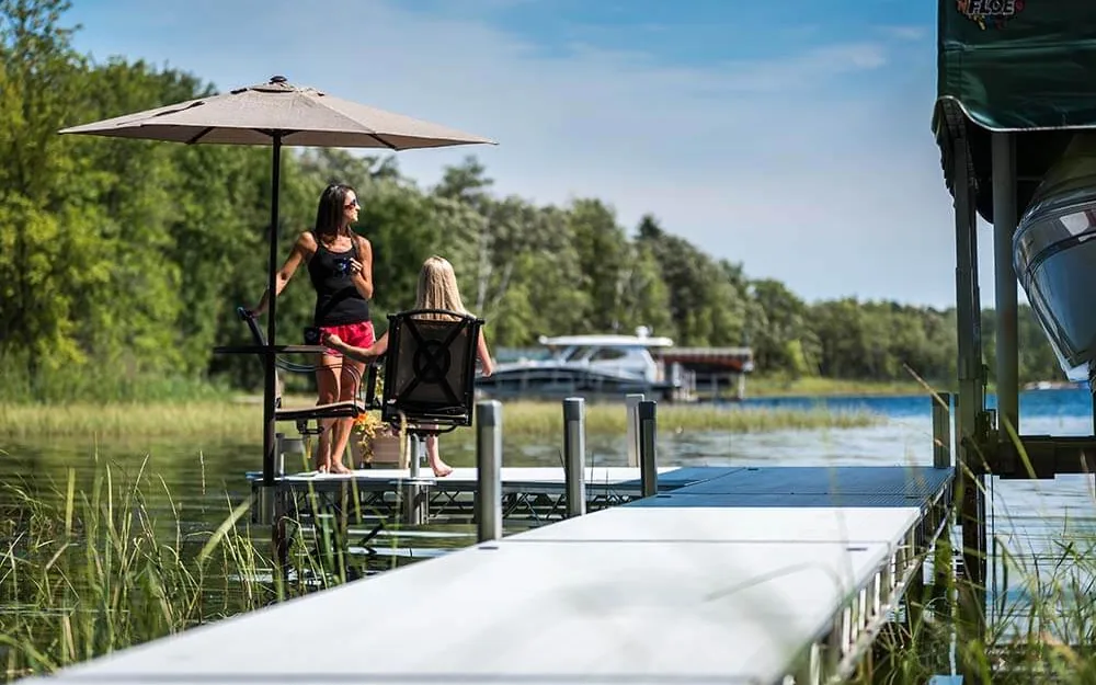 FLOE roll-in dock with shaded seating beside a covered boat lift on a Michigan lake