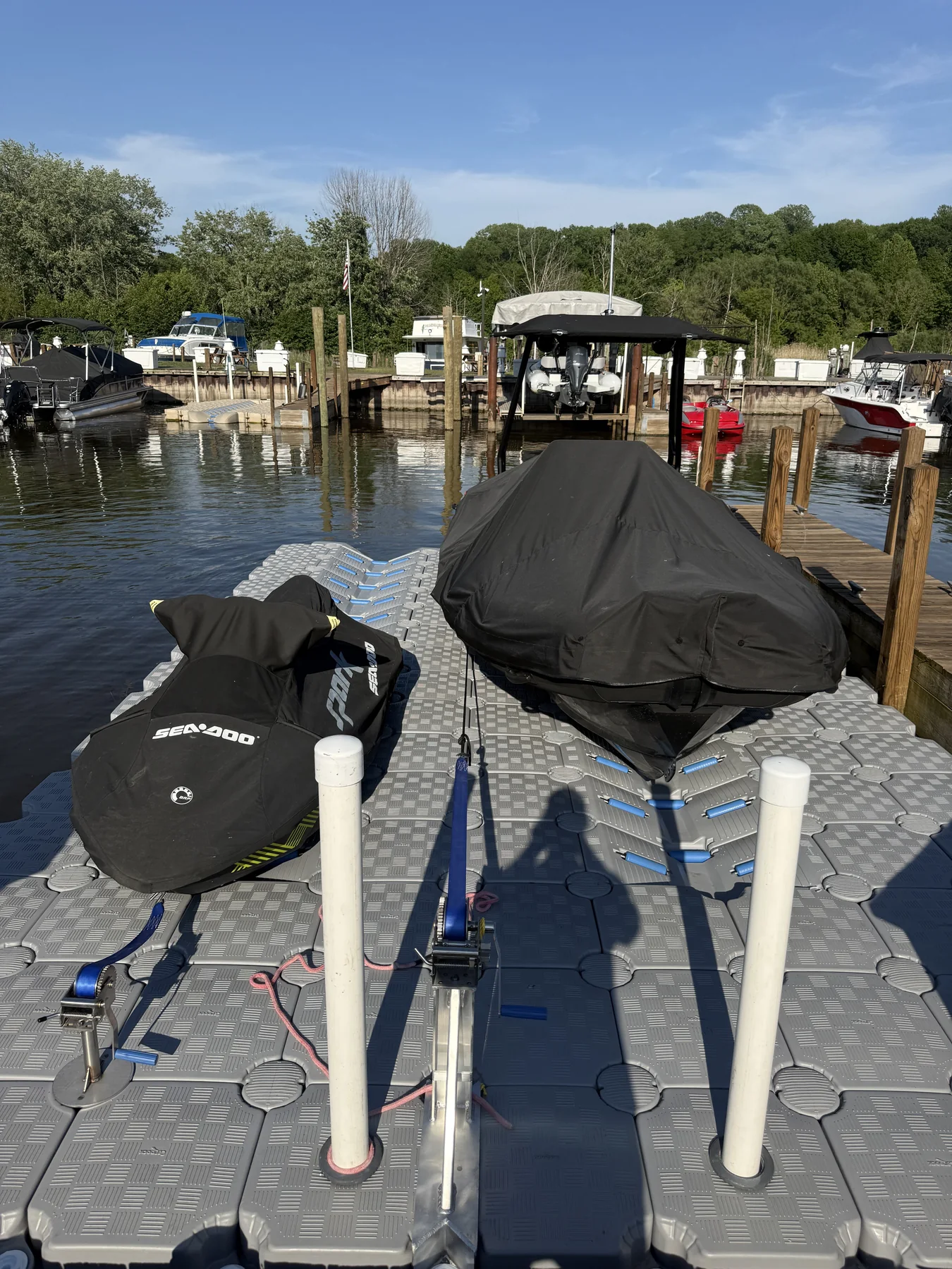 Two personal watercraft parked on drive-on ports beside an existing waterfront dock