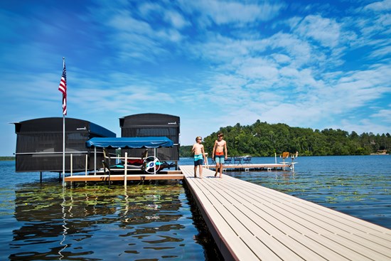 Boat lift with a canopy holding a pontoon boat above the water