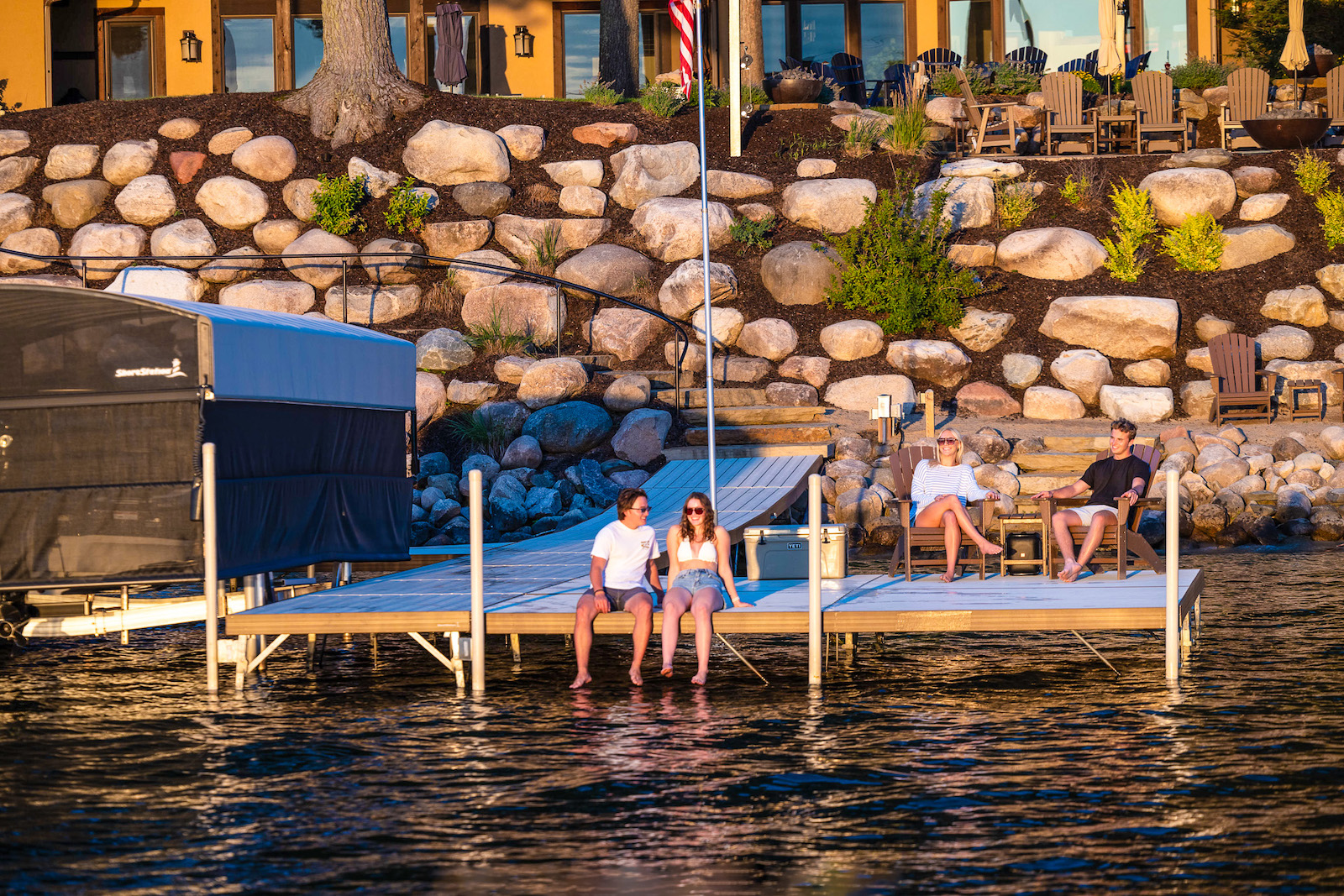 Family and friends relaxing on a leg-supported aluminum dock platform along a Michigan lakefront