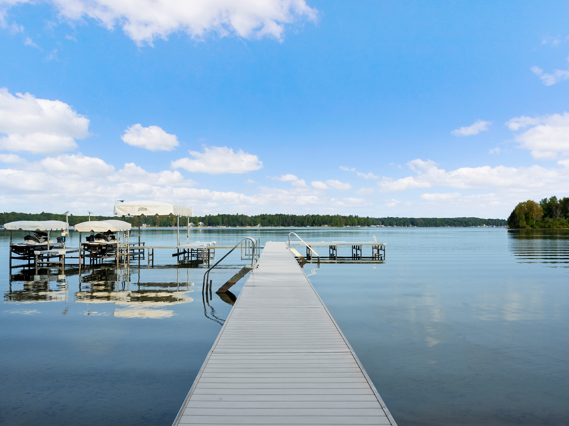 Twin Bay aluminum dock with solid-surface decking on a calm lake